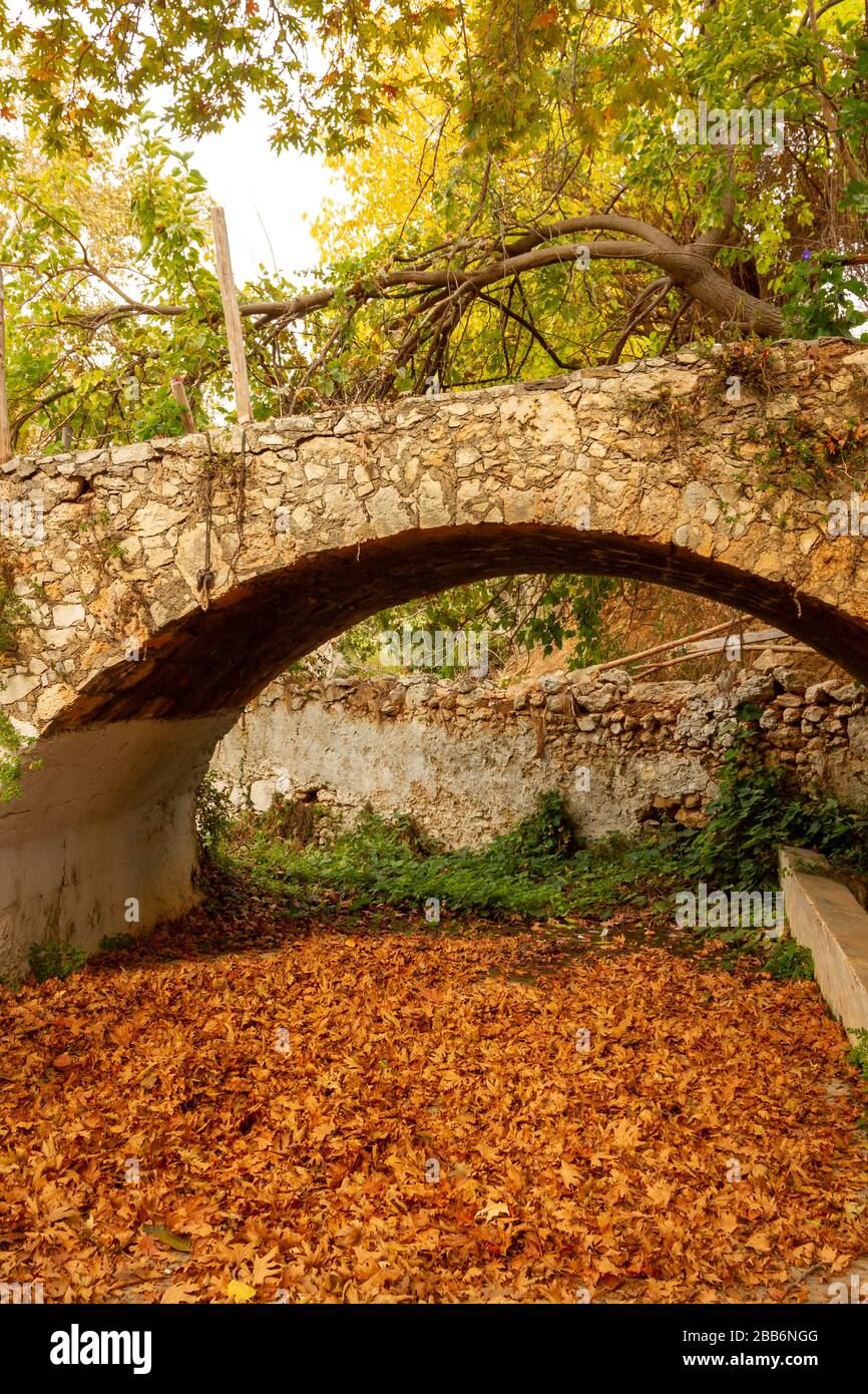 Old stone bridge within a traditional village in Rethymno region, Crete island, Greece, Europe. Stock Photo