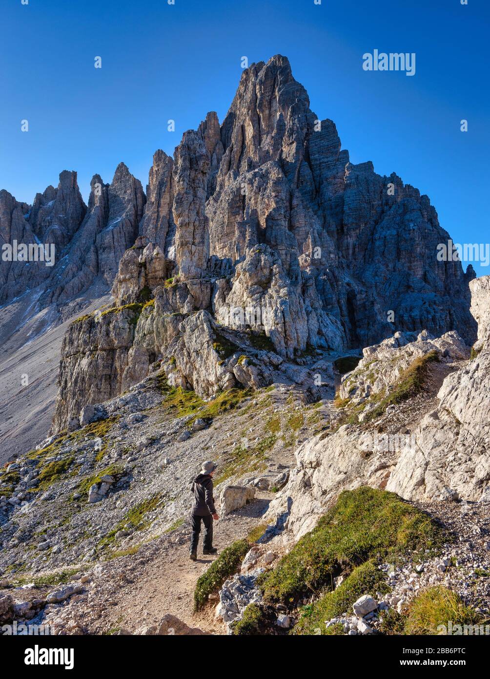 Woman Hiking along a trail, Tre Cime di Lavaredo, Dolomites, South Tyrol, Italy Stock Photo
