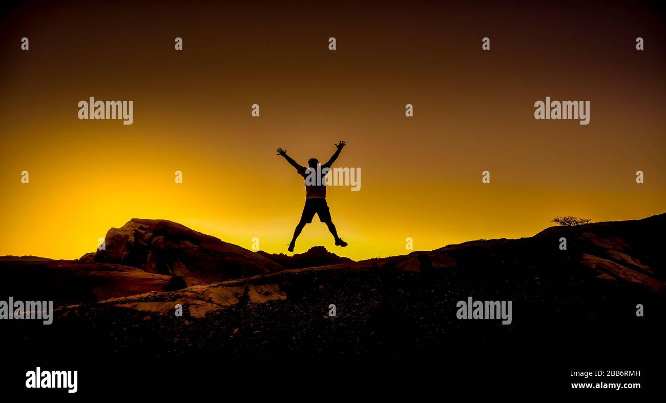 Silhouette of a man jumping in the air in the desert, Valley of Fire State Park, Nevada, USA Stock Photo