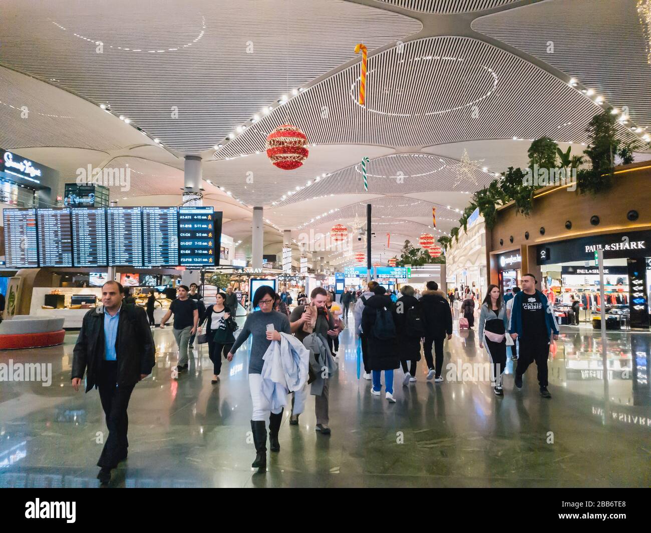 Istanbul, Turkey - February, 11 2020: Passengers in the departure hall of IGA Istanbul Airport terminal, going to the gates. Christmas decoration Stock Photo