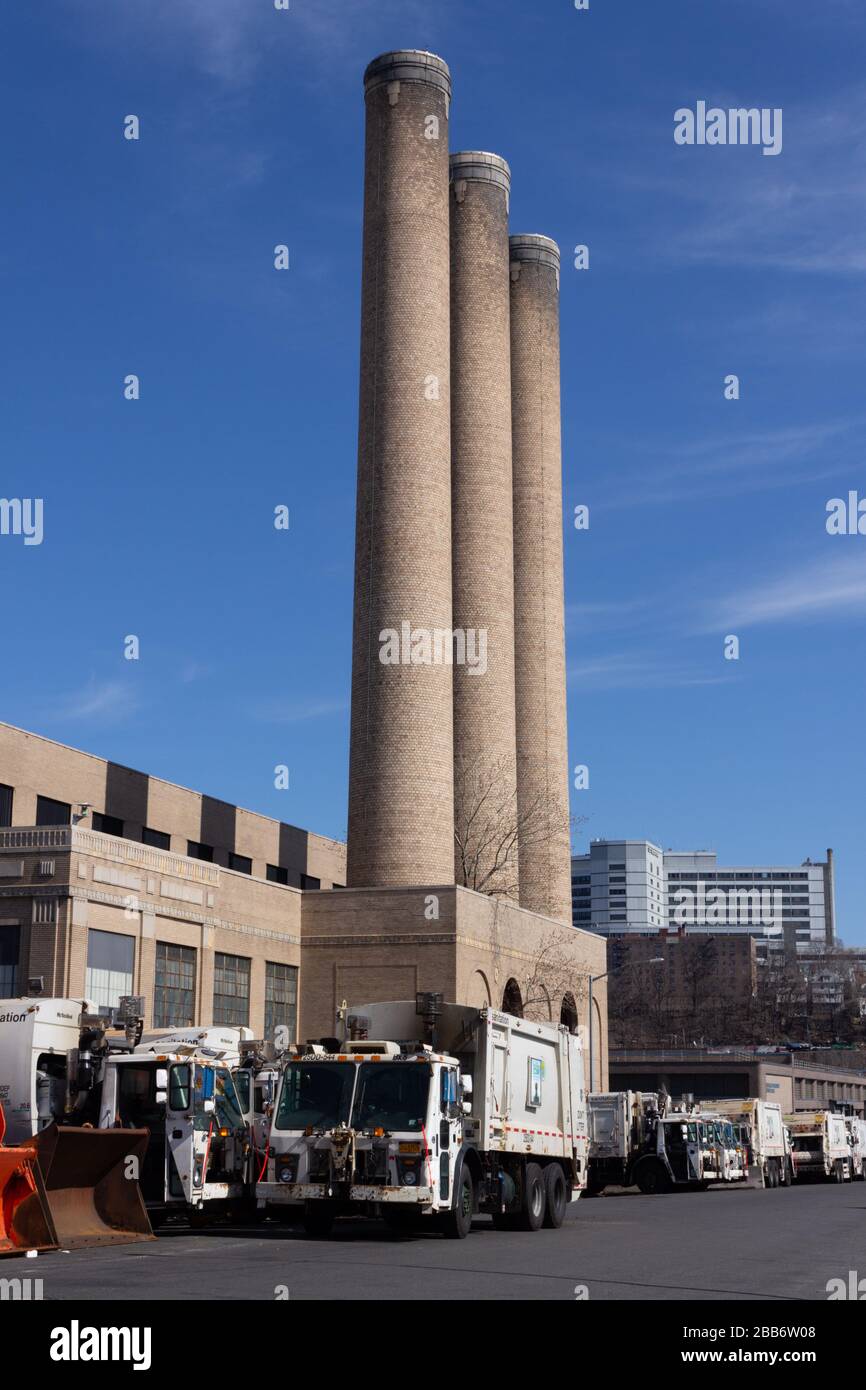 industrial smokestacks rise above the new york city department of sanitation depot in northern manhattan Stock Photo