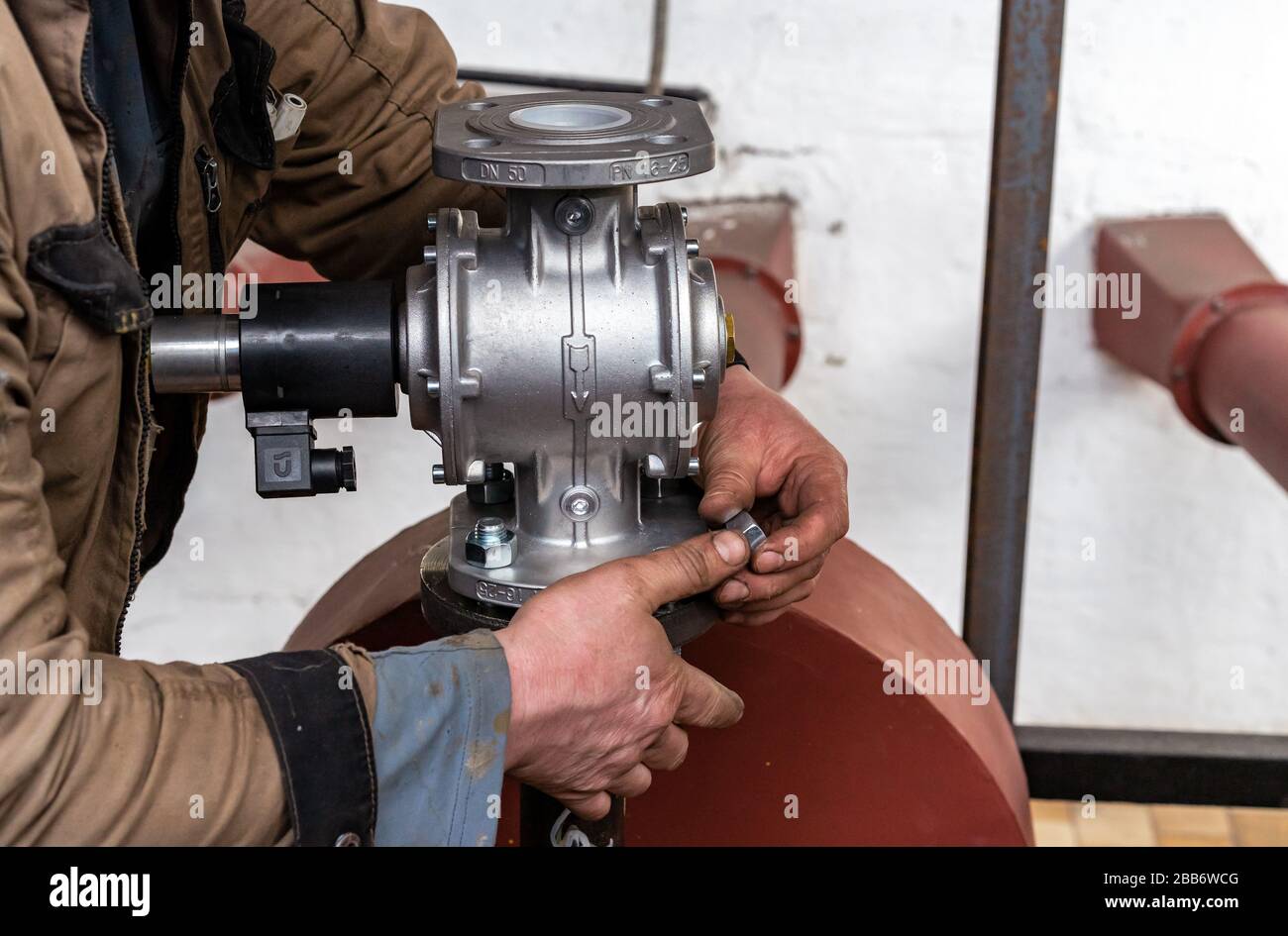 Fitter installs a gas shutoff valve in the boiler room Stock Photo Alamy
