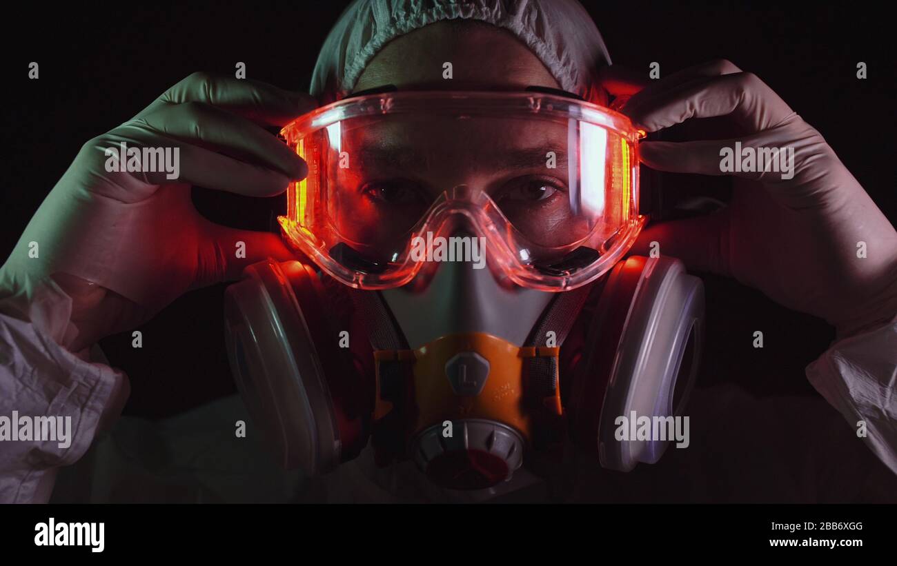 Man in protective costume suit, gas protect medical spray paint mask. Doctor in respirator. Concept health virus coronavirus epidemic. Stock Photo