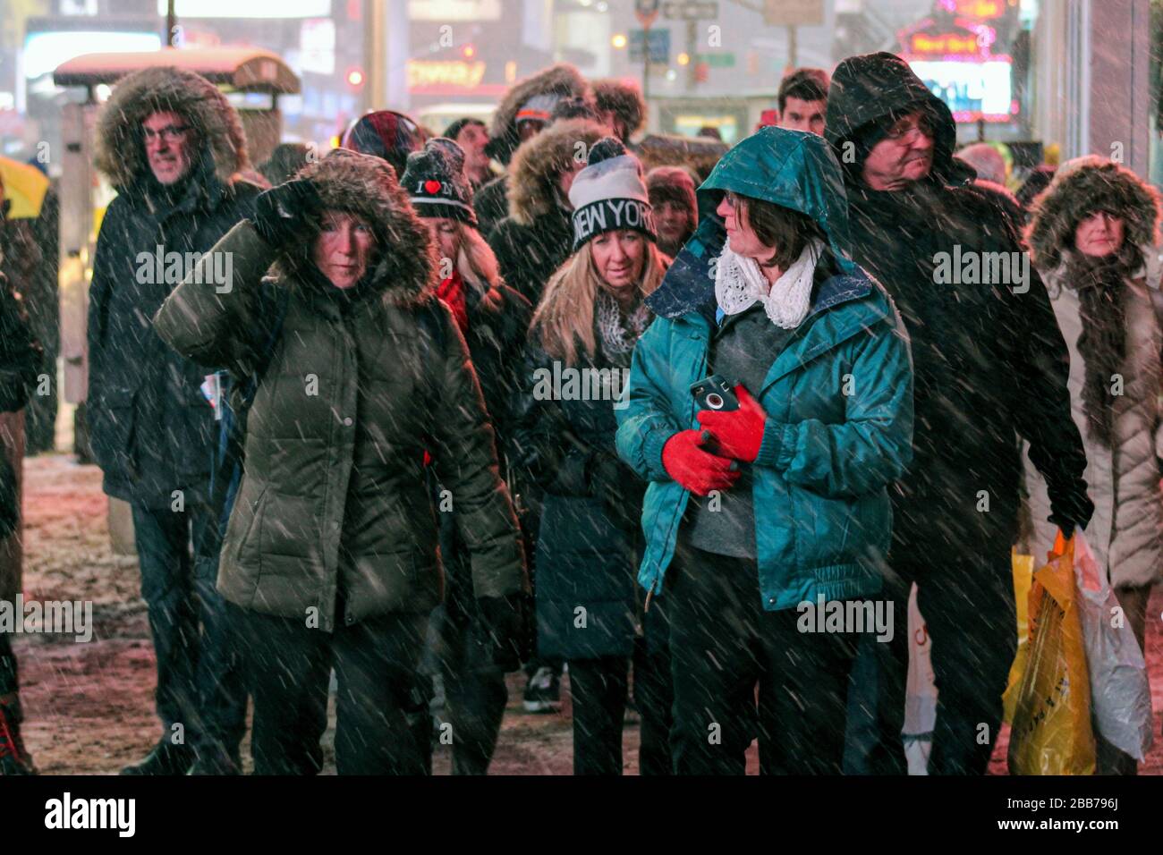 People standing at a red light during heavy snowfall in Time Square, Manhattan, New York City, United States of America Stock Photo
