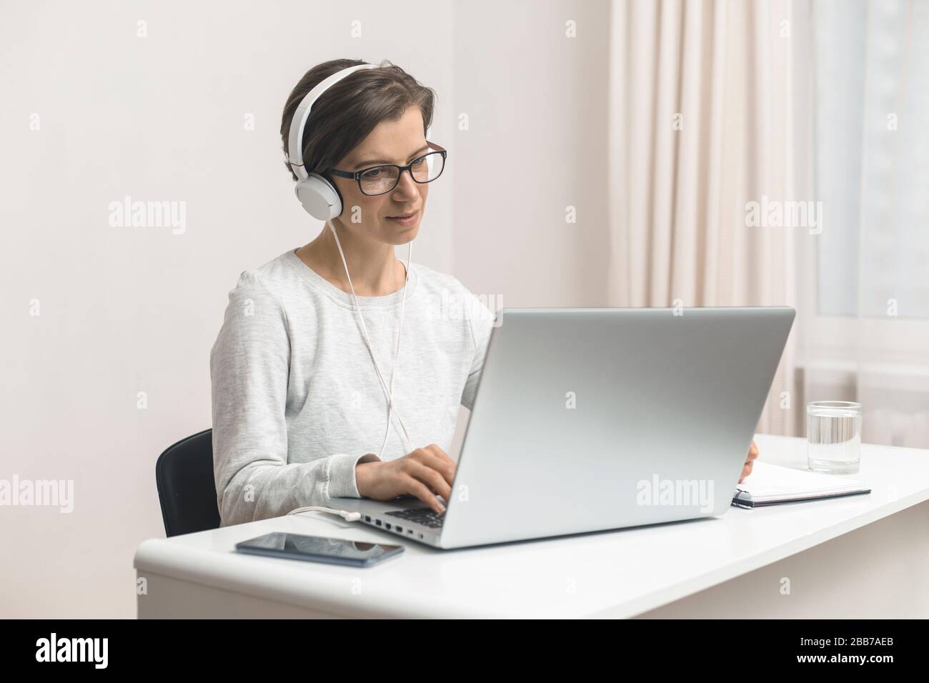 A female freelancer is studying online chatting, talking while sitting at home. Videoconference. Stock Photo