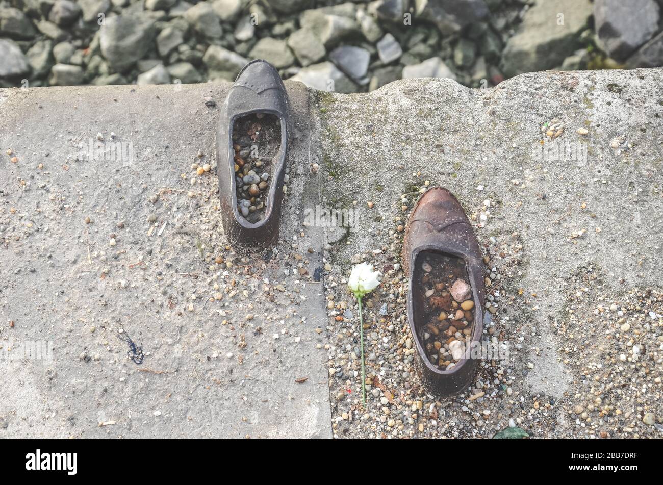 Budapest, Hungary - Nov 6, 2019: Shoes on the Danube Bank. Monument to honor the Jews who were killed by fascists during World War II. Iron shoes with flower photographed from above. Horizontal photo. Stock Photo