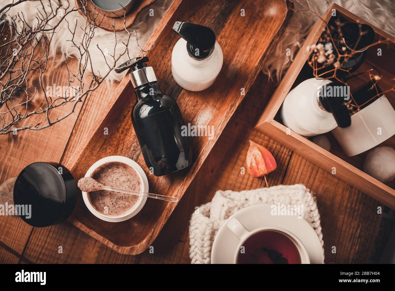 Cosmetic bottles with cosmetics for body care on a wooden table. Spa set on a wooden background. Stock Photo