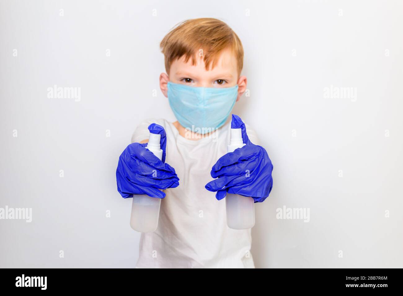 Seven year old boy in a medical mask and latex gloves with an