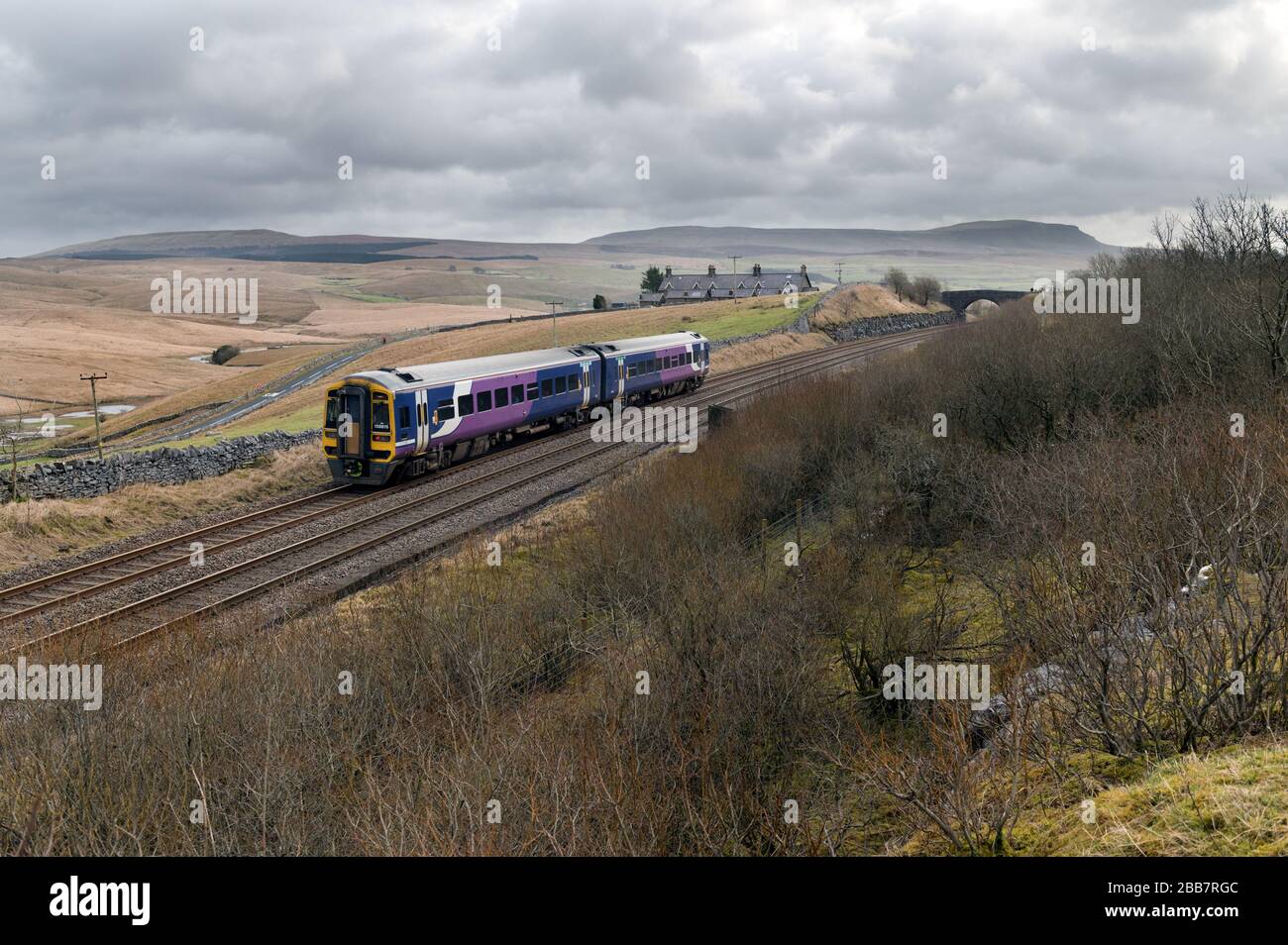 A Sprinter passenger train bound for Leeds passes Salt Lake Cottages near the head of Ribblesdale, on the Settle-Carlisle railway line. Stock Photo
