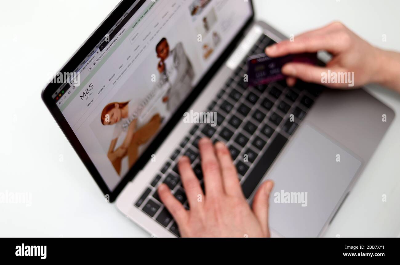 The customer on the Marks & Spencer website is pictured holding a bank card as Supermarket websites are overwhelmed by online orders during the COVID-19 Coronavirus pandemic as the UK continues in lockdown to help curb the spread of the coronavirus. Stock Photo