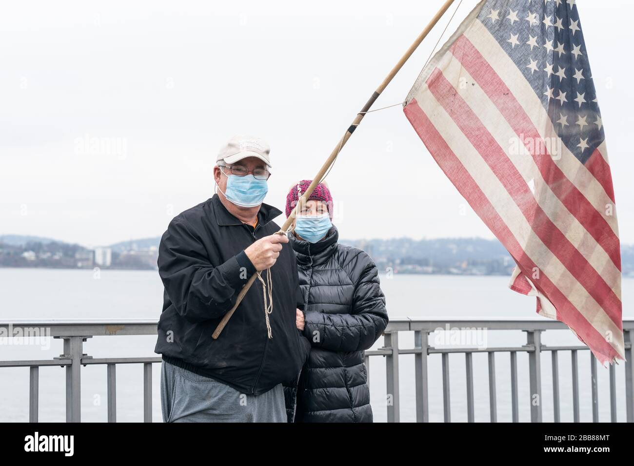 New York, NY - March 30, 2020: Residents of Brooklyn Roy and Lois Schneit greet USNS Comfort Navy ship with 1000 beds to relief NYC hospitals on COVID-19 pandemic passes under Verrazzano-Narrows bridge on its way in New York harbor Stock Photo