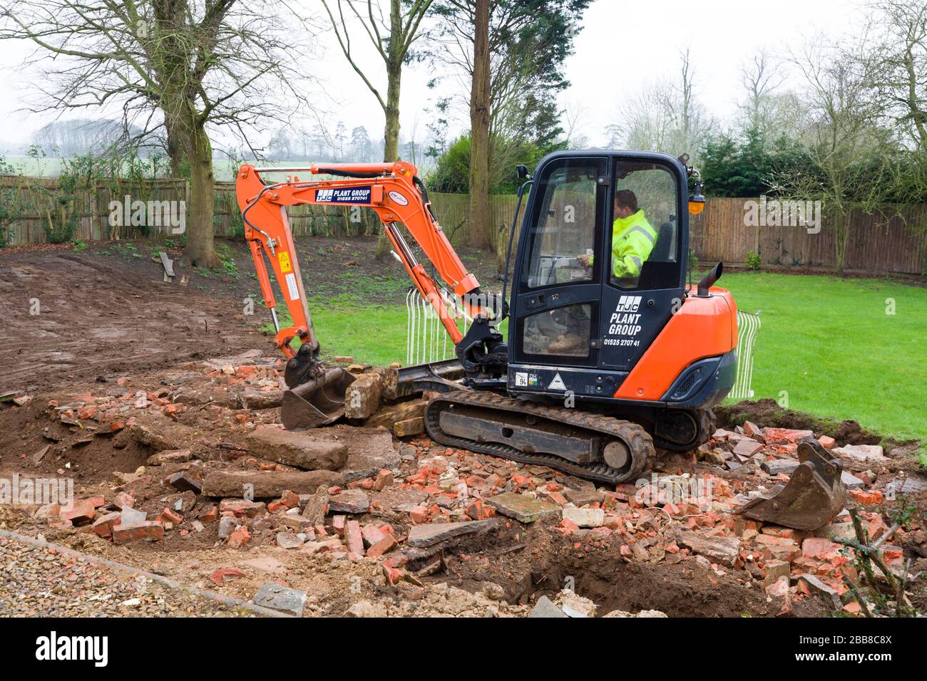 BUCKINGHAM, UK - February 13, 2016. Digger, bulldozer clearing rubble in preparation for hard landscaping a garden in UK Stock Photo