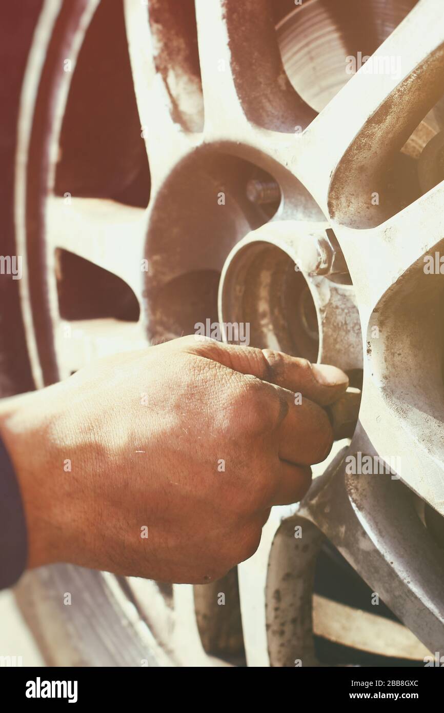 A man hand during wheel nut tightening process close up view Stock