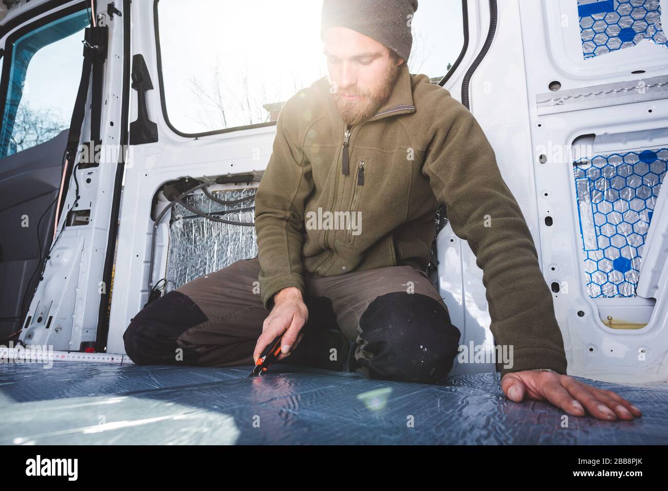 Man working inside his DIY camper van Stock Photo