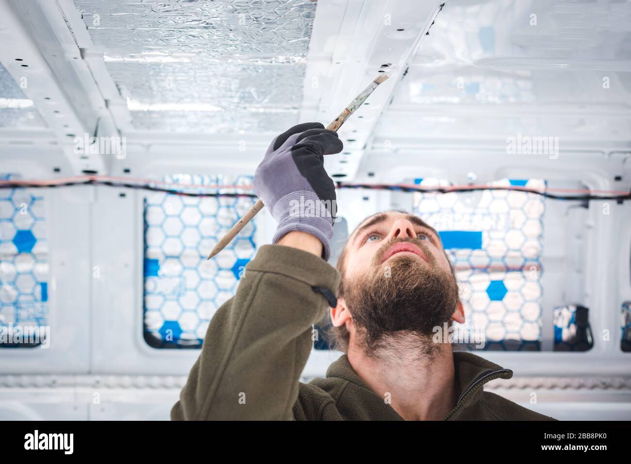 Man painting small areas inside a van Stock Photo Alamy