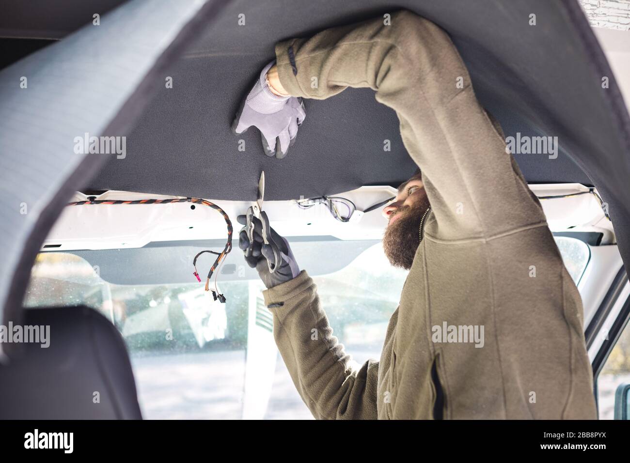 Man installing insulation inside his camper van Stock Photo