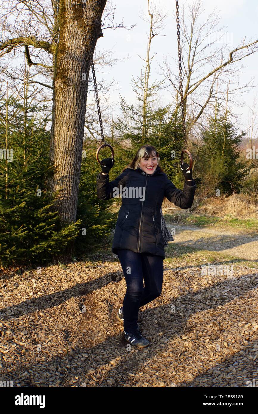 junge Frau turnt an Ringen auf dem Fitness-Parcour, Neuenrade, Nordrhein-Westfalen, Deutschland Stock Photo