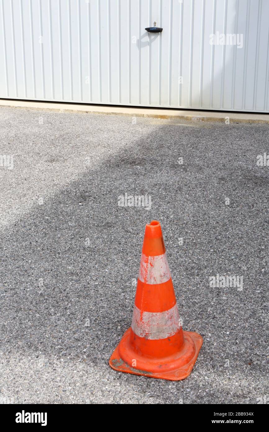 Plot en plastique rayé orange indiquant une interdiction de se garer devant la porte du garage. Haute-Savoie. France. Stock Photo