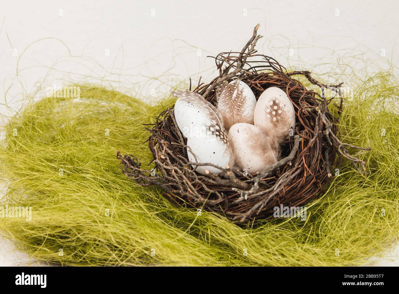 Pastel Easter eggs in bird's nest on a green grass Stock Photo - Alamy