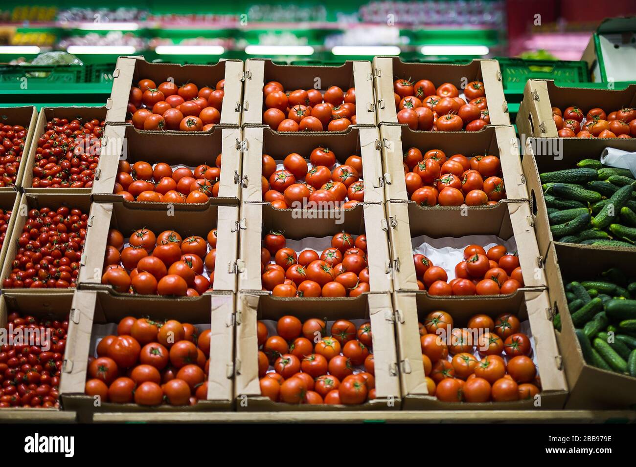 Beautiful red tomatoes in cardboard boxes, for sale on a market shelf ...