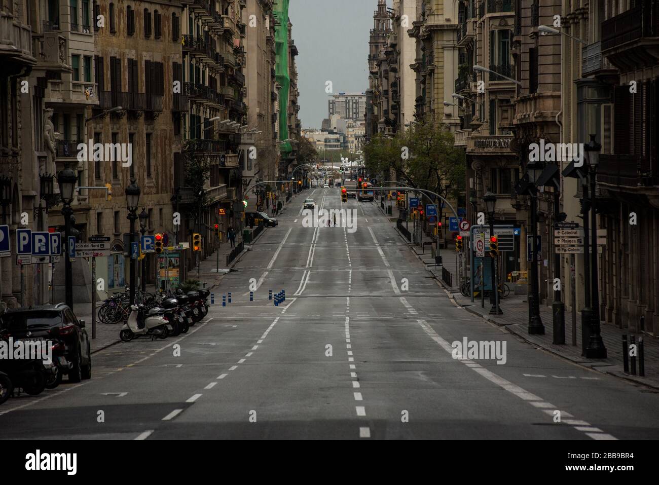 Barcelona, Catalonia, Spain. 30th March 2020. A woman crosses the empty Via Laietana street in Barcelona. Daily coronavirus deaths fall slightly with 812 Covid-19 victims in the last 24 hours in Spain, Spanish government has ordered new lockdown restrictions. Credit:Jordi Boixareu/Alamy Live News Stock Photo