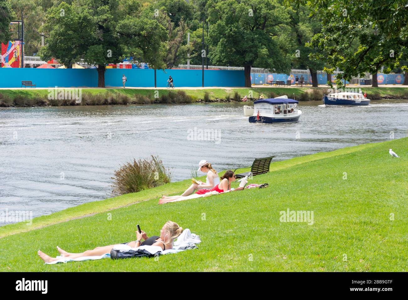 Sunbathers on banks of Yarra River, Alexandra Gardens, Southbank, City Central, Melbourne, Victoria, Australia Stock Photo