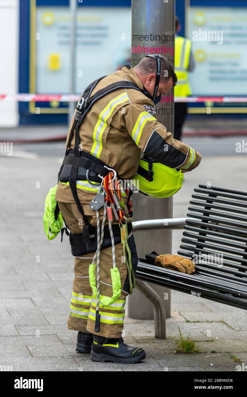 Fire Service dealing with a fire next to Sainsbury's supermarket in Westcliff on Sea, Essex, UK during COVID-19 lockdown. Firefighter kitting up Stock Photo