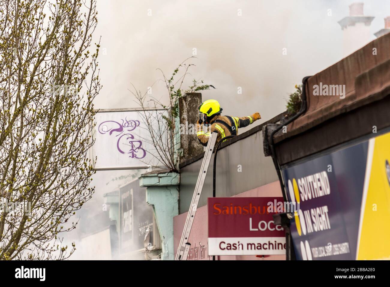 Fire Service dealing with a fire next to Sainsbury's supermarket in Westcliff on Sea, Essex, UK during COVID-19 lockdown. Fire fighter directing radio Stock Photo
