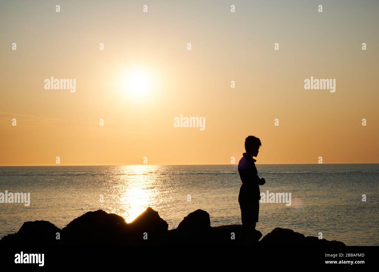 view of a fisherman shadow on the rocks of Punta Ballena coastline on the bay of Solanas, atlantic ocean, Maldonado, Uruguay Stock Photo