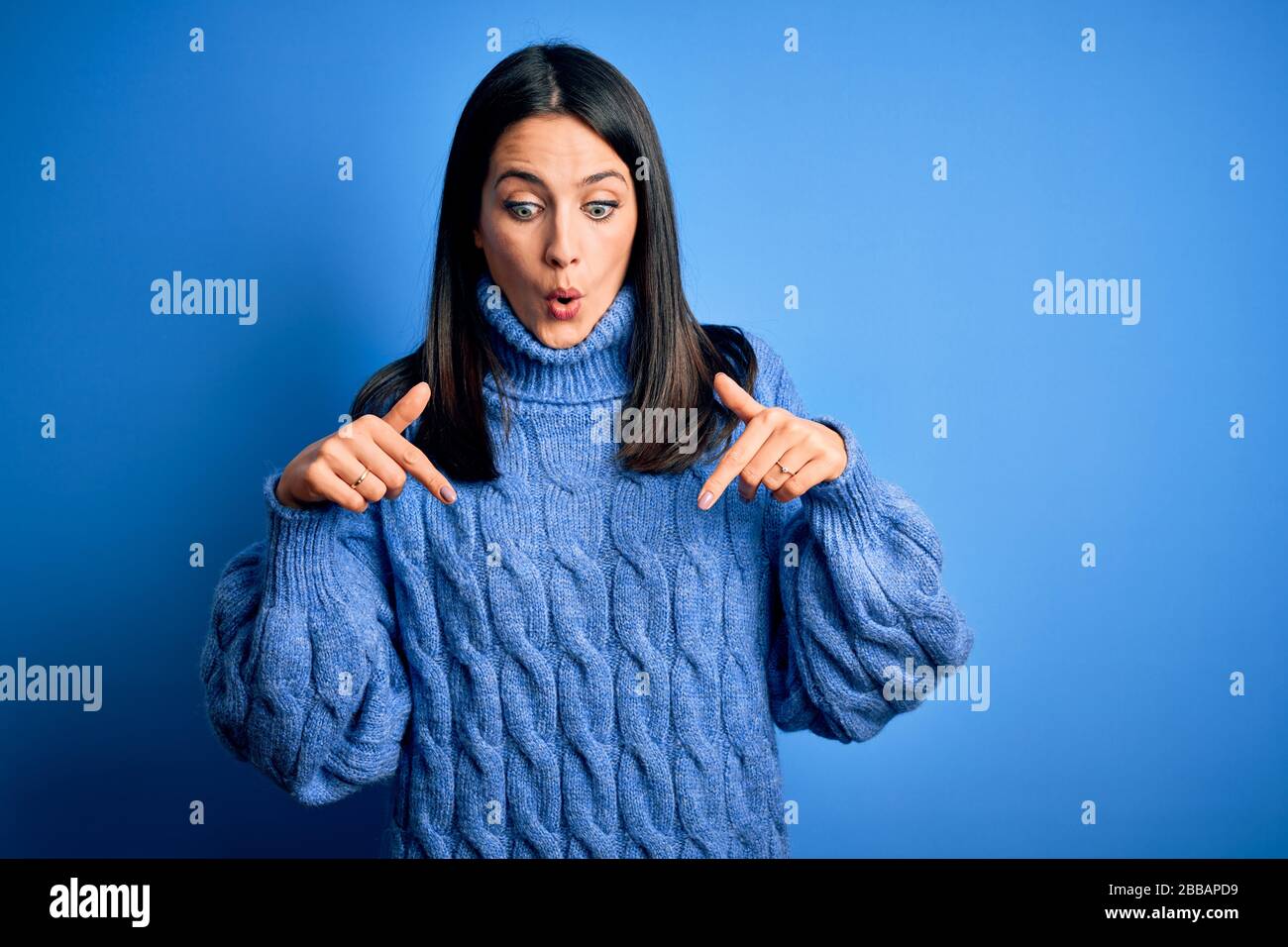Young brunette woman with blue eyes wearing casual turtleneck sweater ...