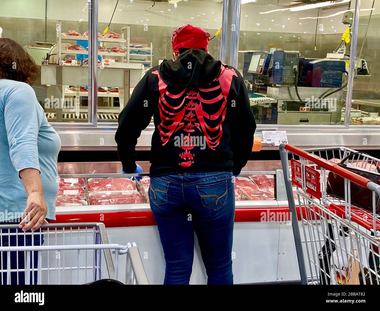 Santa Barbara, California, USA. 27th Mar, 2020. Panic Shopping during the Corona Virus pandemic: one woman at Costco wears a sweat shirt displaying a skeletonÃs lung area, which is oddly apropo given this is the part of the body that Covid-19 attacked. Credit: Amy Katz/ZUMA Wire/Alamy Live News Stock Photo