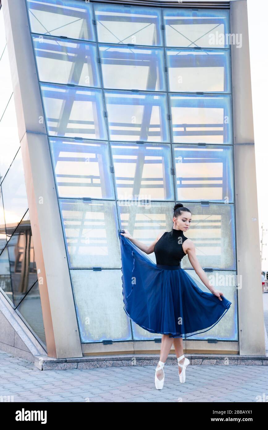 Beautiful ballerina in blue dress and pointe, dancing and practicing