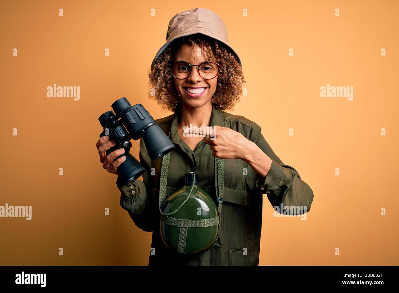 African american tourist woman wearing explorer hat and water canteen ...