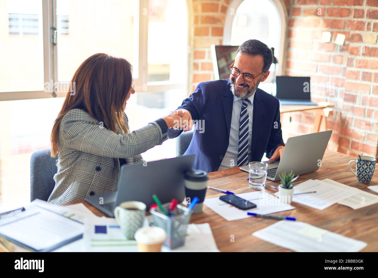 Two middle age business workers smiling happy and confident. Working ...