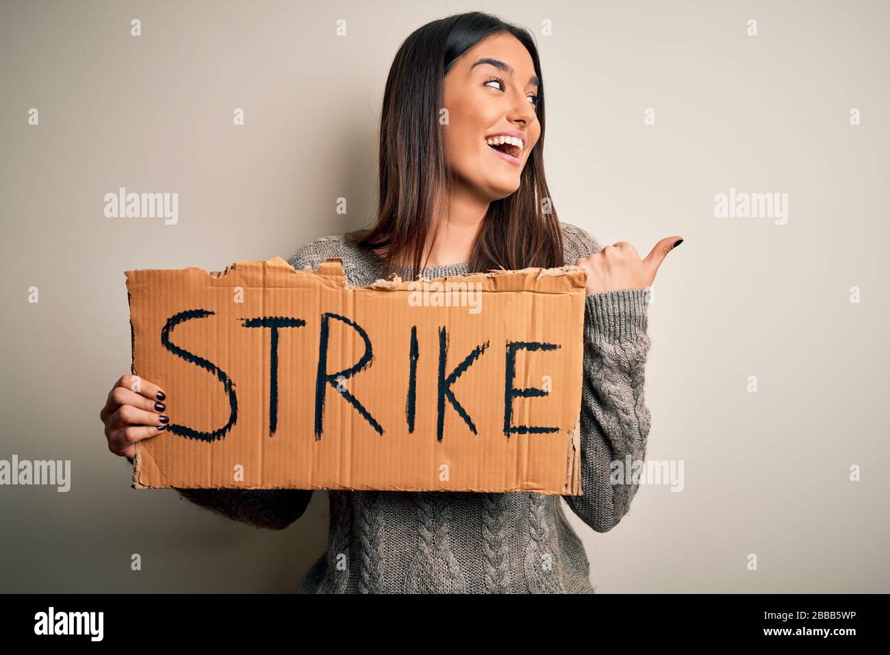 Young beautiful brunette activist woman protesting holding poster with ...