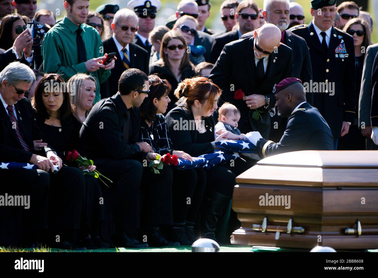 'U.S. Army Brig. Gen. Xavier Brunson, commander of U.S. Army Special Forces Command, presents an American Flag to Declan, son of U.S. Army Sgt. First Class Matthew Q. McClintock, during the graveside service for McClintock in Section 60 of Arlington National Cemetery, March 7, 2016, in Arlington, Va. McClintock was killed in action Jan. 5, 2016, in Afghanistan. (U.S. Army photo by Rachel Larue/Arlington National Cemetery/released); 7 March 2016, 14:51; Graveside service for U.S. Army Sgt First Class Matthew Q. McClintock takes place in Section 60 of Arlington National Cemetery; Arlington Natio Stock Photo
