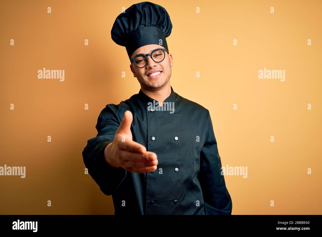 Handshake Chef Young brazilian chef man wearing cooker uniform and hat over isolated ...