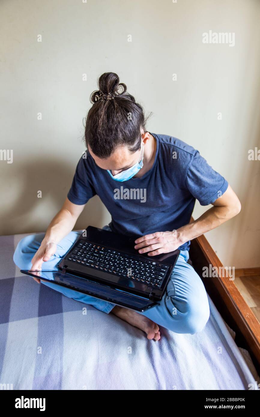 Stay at home concept. Quarantine due coronavirus pandemic. business man working from home, wear a protective mask. Remote work, learning due to the Stock Photo