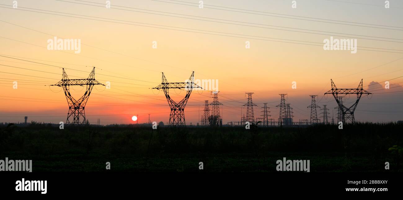 In the evening, high voltage towers silhouette and a beautiful sunset ...