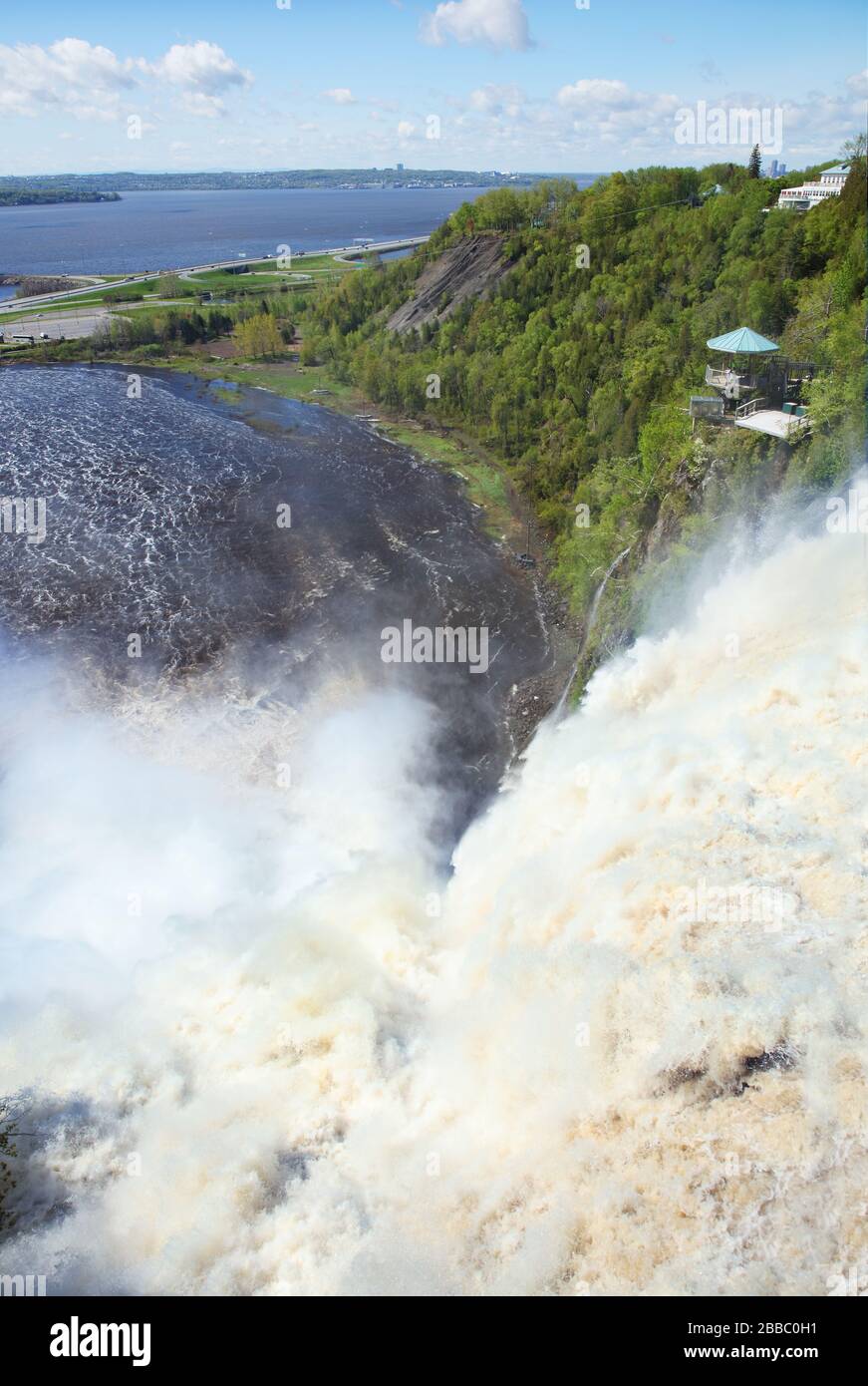 View from above the Montmorency Falls as water crashes into a bassin that in turn empties into the St. Lawrence River in the background, Parc de la Chute-Montmorency near Quebec City, Quebec, Canada Stock Photo