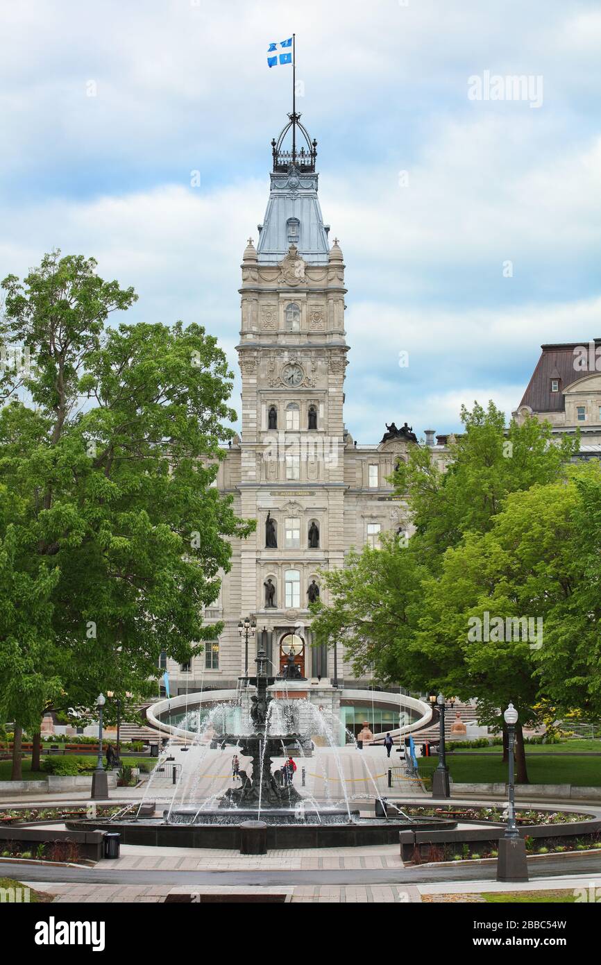 Fountaine de Tourny (Tourny Fountain) behind which is the clock tower of the the Parliament Building of Quebec, Quebec City, Quebec, Canada Stock Photo