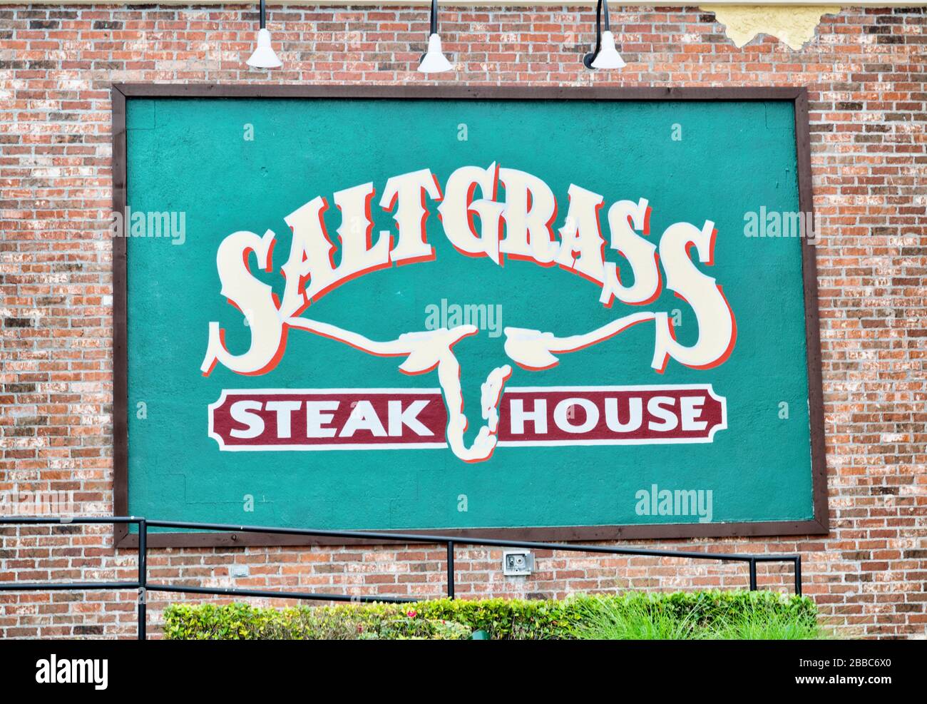 Saltgrass Steakhouse wall sign on their building in Houston, TX. Historic American restaurant serving steaks, chicken and seafood with a rustic feel. Stock Photo