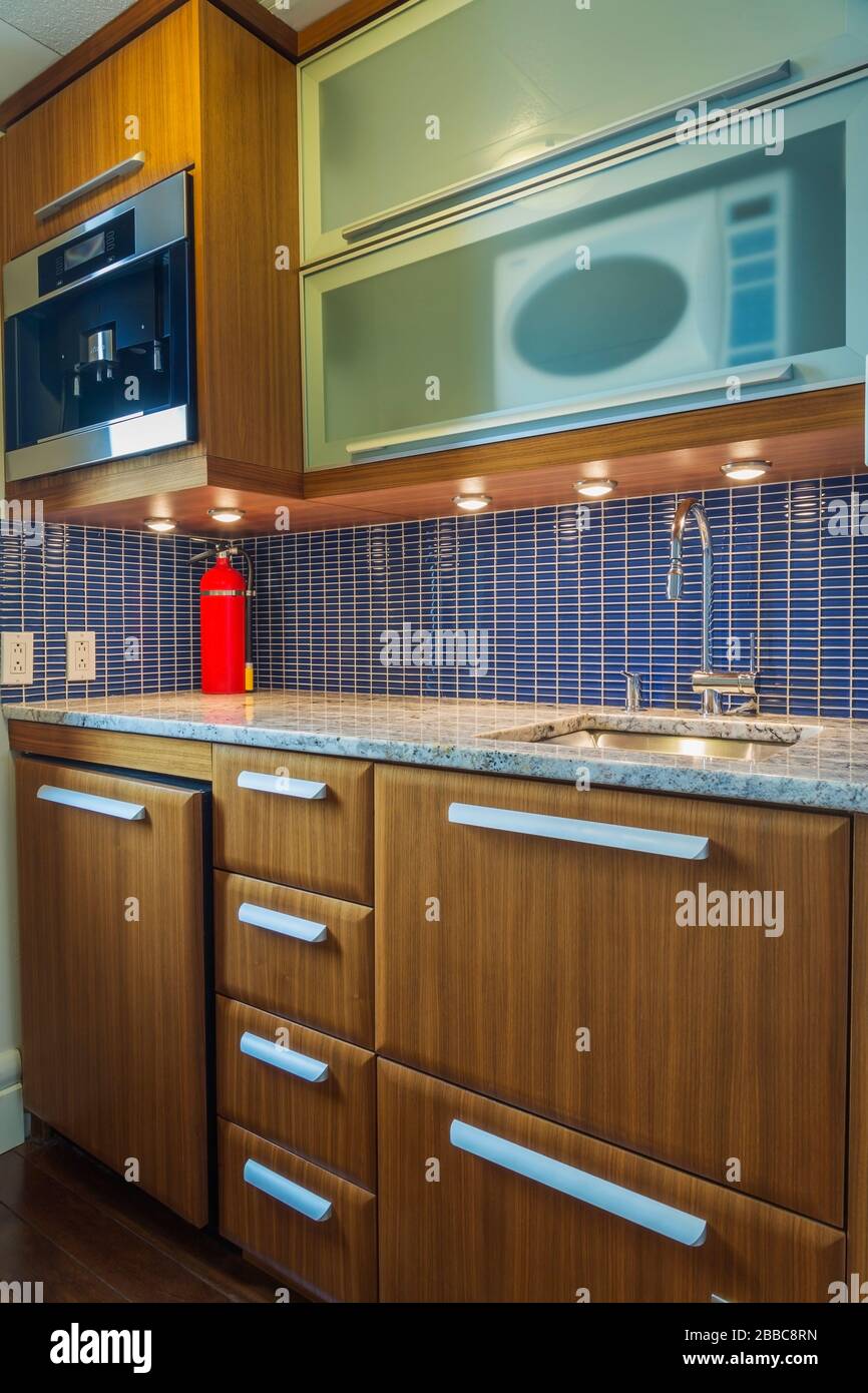 Small kitchenette with nuanced granite countertop and blue ceramic backsplash inside a modern luxurious multistory penthouse condominium unit, Old Montreal, Quebec, Canada. This image is property released for publication in calendars and editorial use. EUPR0359 Stock Photo