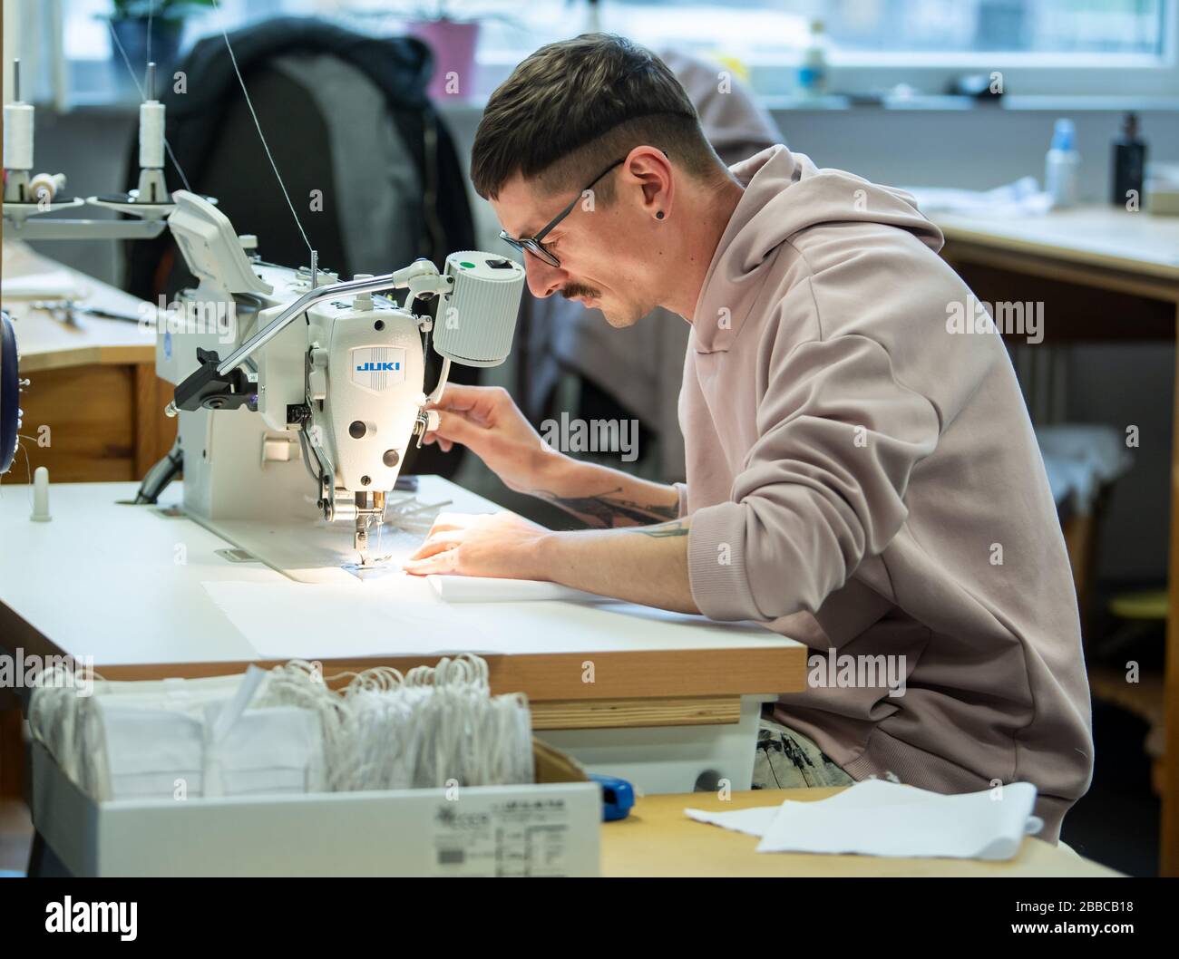 Berlin, Germany. 30th Mar, 2020. Tailor Eric De Bastos sews cotton  breathing masks in the workshop of Bühnenservice Berlin. Currently, the  central theatre workshop of the opera houses not only tailors costumes,