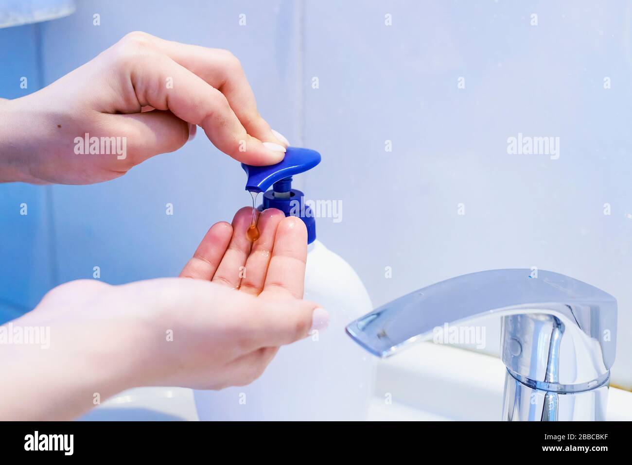Close-up view of woman using soap and washing hands under the water tap ...