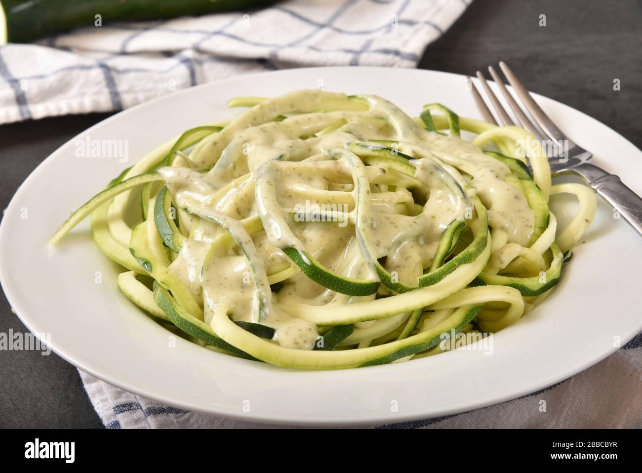 Creamy basil pesto alfredo sauce on spiralized zucchini squash Stock