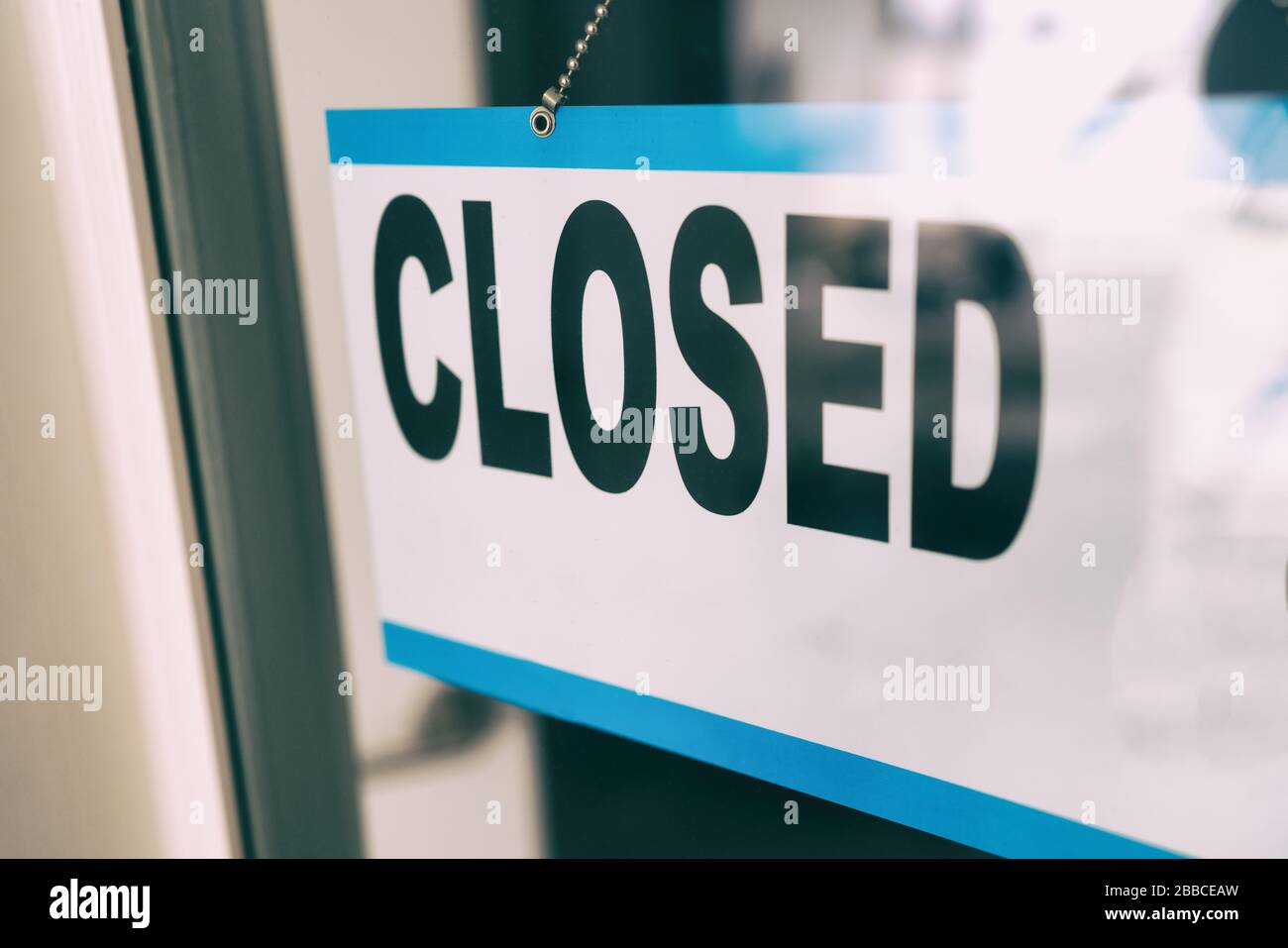 Closed sign on retail business store window because of COVID-19 Pandemic outbreak. Government shutdown of restaurants, shopping stores, non essential services. Stock Photo