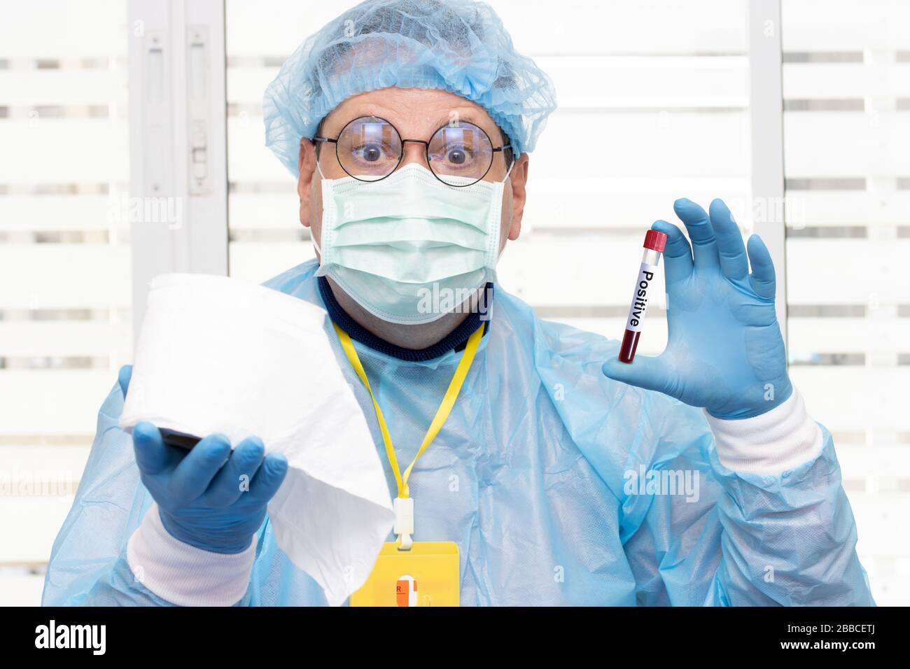Doctor in protective suit holding tube with positive blood test results