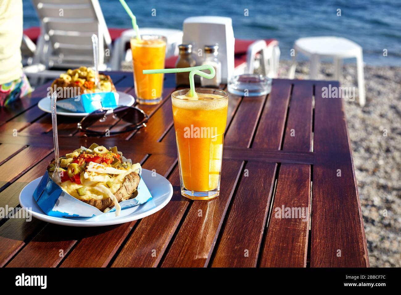 Stuffed potato with vegetables and cheese and Orange juice in sea view restaurant in Turkey Stock Photo