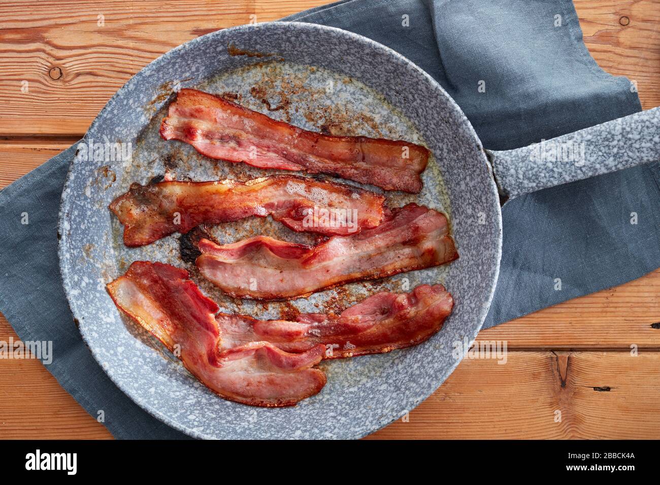 bacon fry frying pan crisp rasher rashers streaky enamel cooked tea towel meat pork smoked unsmoked breakfast fry up English full 5 five BLT Stock Photo